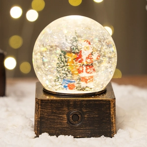 Boule à neige de Noël lumineuse avec Père Noël et renne sur socle en bois