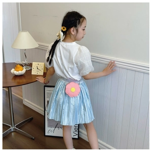 Kids wearing a pink flower-shaped crossbody bag with a blue pleated skirt and white top