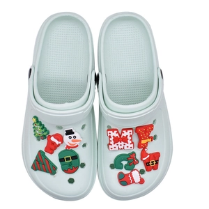 Christmas themed PVC charms on mint green garden clogs featuring snowman and tree