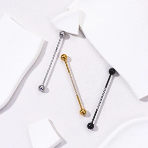Three surgical steel industrial barbell ear piercings with rows of cubic zirconia stones