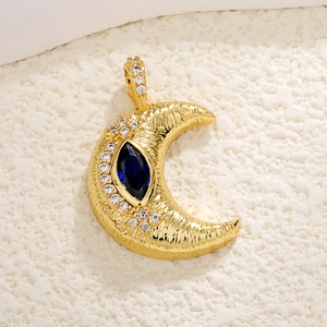 Macro view of gold crescent moon pendant with blue marquise stone and zircon accents