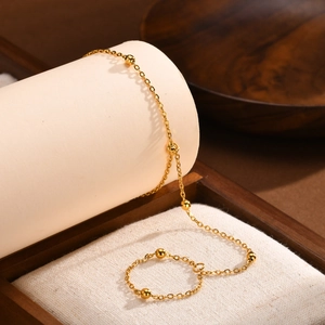 Detail of double-layer 18K gold-plated beaded chain bracelet and matching link ring set