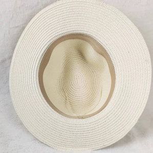 Macro view of woven straw hat interior featuring beige sweatband and intricate stitching