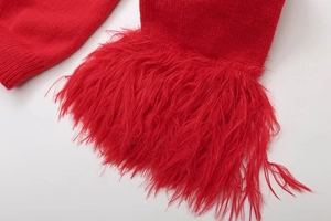 Detaillierte Makroansicht des roten Strickpullovers mit luxuriösem Kunstpelz am Ärmel