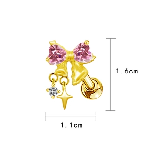 Detailed close-up of gold ear stud with pink heart zircon and starry dangling charm