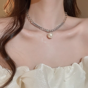 Close-up of beaded necklace with grey pearl pendant worn on model neck for luxury style