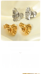 Detail showing irregular crumpled texture on 18K gold and silver heart-shaped stud earrings
