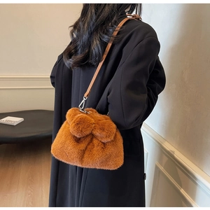 Detail of brown plush bucket bag with soft faux fur texture and slim leather strap