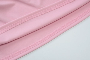 Gros plan sur les coutures et la finition de qualité du haut bandeau en tricot rose
