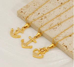 Detailed view of three 18K gold plated anchor necklaces with sparkling zircon inlays
