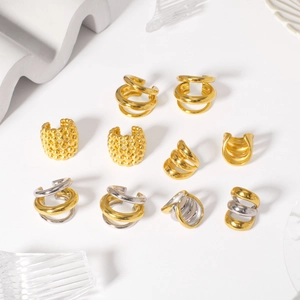 18K gold plated and silver stainless steel ear cuffs set on creative props background