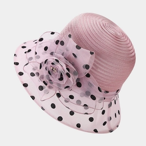 Close-up of pink sun hat featuring polka dots and a large sheer organza flower decoration