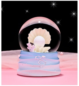 Macro shot of luminous shell and pearl inside a crystal ball with coral details