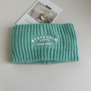 Detail eines mintgrünen Strickstirnbandes mit weißem Stockholm-Stick und Tulpendekoration