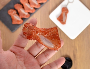 Macro detail of realistic roasted chicken wing food model keychain with glossy texture