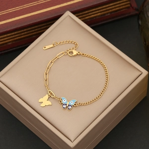 Golden stainless steel butterfly charm bracelet with evil eye enamel detail on a jewelry box