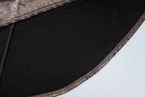 Gros plan sur le tissu métallique doré brillant avec doublure noire et détails de couture