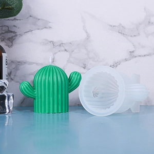 Macro shot of cactus-shaped silicone mold and finished green handmade wax candle