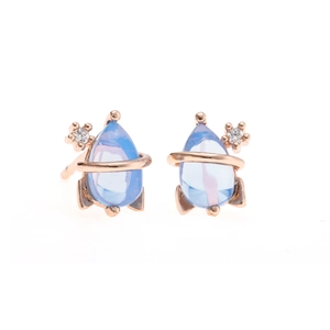 Macro detail of planet-shaped rose gold earring with blue teardrop gemstone and zircons