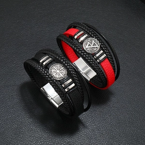 Detail view of multilayer woven leather bracelets with silver magnetic clasps and metal charms