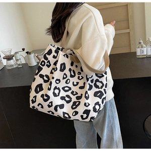 Vue portée du grand sac cabas en toile à motif léopard dans un cadre de café chaleureux
