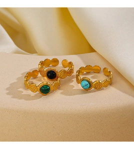 Detail of vintage gold adjustable rings with turquoise and obsidian stone inlays