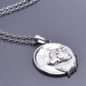 Detailed macro view of a silver stainless steel wolf head relief pendant on an O-chain