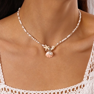 Detailed close-up of beaded ocean necklace with shell, starfish, and pearl charms