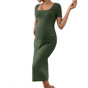 Détail de la texture en maille vert foncé et fente latérale sur cette robe de maternité