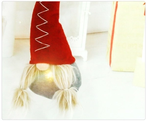 Gnome de Noël lumineux avec chapeau rouge et tresses dorées, détail de la décoration LED