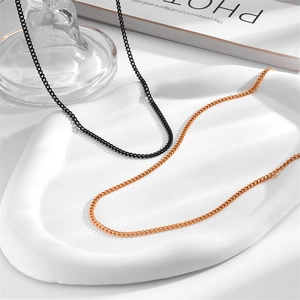 Detail view of stainless steel cross chain necklaces in black and rose gold finishes