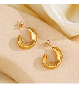 Détail des boucles d'oreilles en forme de C dorées 18K sur pierre texturée