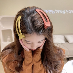 Matte finish large duckbill hair clips shown worn by a model in warm ginger and brick red