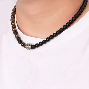 Close-up of 8mm black obsidian and tiger eye beaded necklace on male model's neck