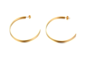 Macro detail of gold C-shape flat hoop earrings with surgical steel post on white background