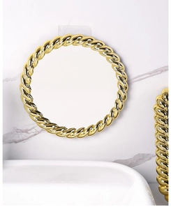Close-up of golden round vanity mirror with twisted textured frame on marble