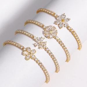 Détail de quatre bracelets fleurs plaqués or avec des pierres en zircone scintillantes