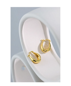 Macro shot of polished gold U-shape earrings featuring a clear S925 hallmark on the post