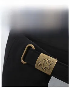 Detail of adjustable bronze metal buckle with embossed logo on black cotton baseball cap