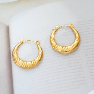 Macro view of 18K gold plated hoop earrings with textured geometric diagonal stripes