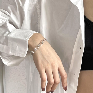 Detailed view of silver thick link chain bracelet worn on wrist with polished finish