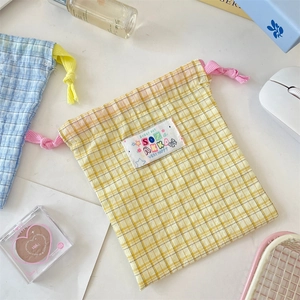 Detail of plaid cotton drawstring storage bags with decorative colorful woven patches