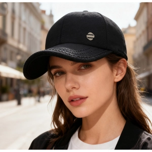 Detail of black wool baseball cap featuring decorative stitching and silver metal plate