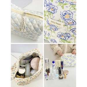 Pochette per trucchi trapuntata con motivi floreali blu e cerniera in quattro prospettive