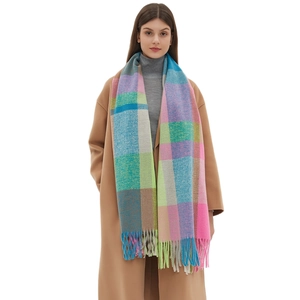 Thick colorful plaid scarf with tassels featuring rainbow checks worn by model