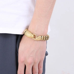 Detailed view of the gold snake head clasp and scale texture on men's steel bracelet