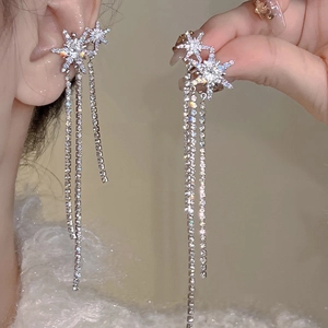 Détail des boucles d'oreilles étoile en argent avec pampilles longues et zircons blancs