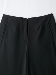Détail du pantalon décontracté noir à taille haute, ceinture et poche latérale