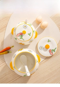 Detail of floral ceramic lard jar with daisy pattern and matching spoon on wooden table