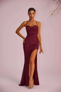 Detail of burgundy sequin evening dress featuring spaghetti straps and high side slit